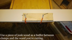 using a piece of junk wood as a buffer between clamps and the wood you're cutting