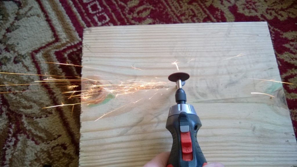 using a dremmel tool to cut a notch into a stripped screw as sparks fly