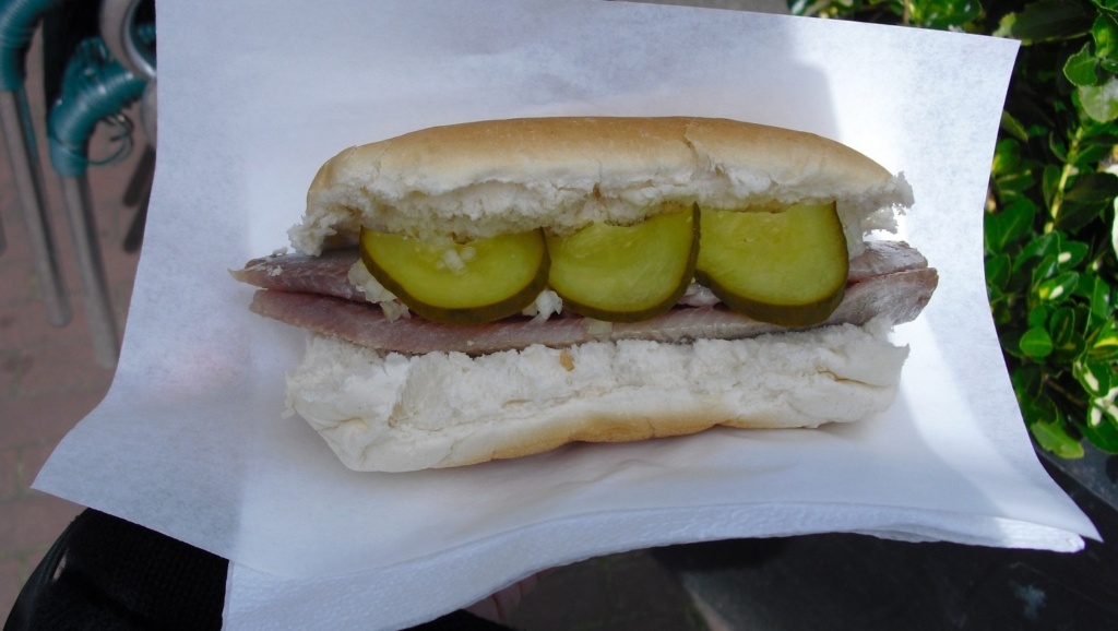raw herring sandwich with pickels and onions in amsterdam