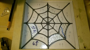 working on stained glass spiderweb in the basement workshop cage