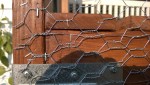 stapling chicken wire to the outdoor cat enclosure / catio