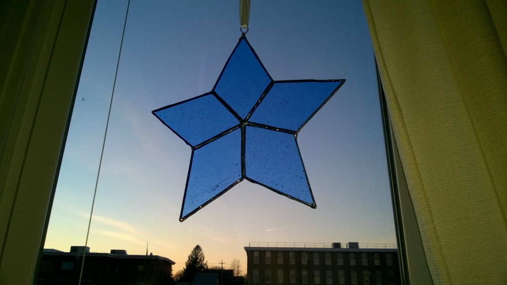 blue stained glass star hanging in living room window
