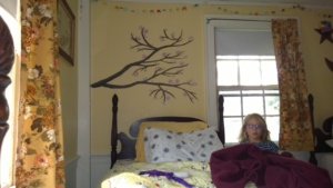 meara standing in front of the cherry blossom branch i painted on her wall