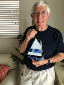 dad holding the stained glass sailboat cat boat i made him for christmas