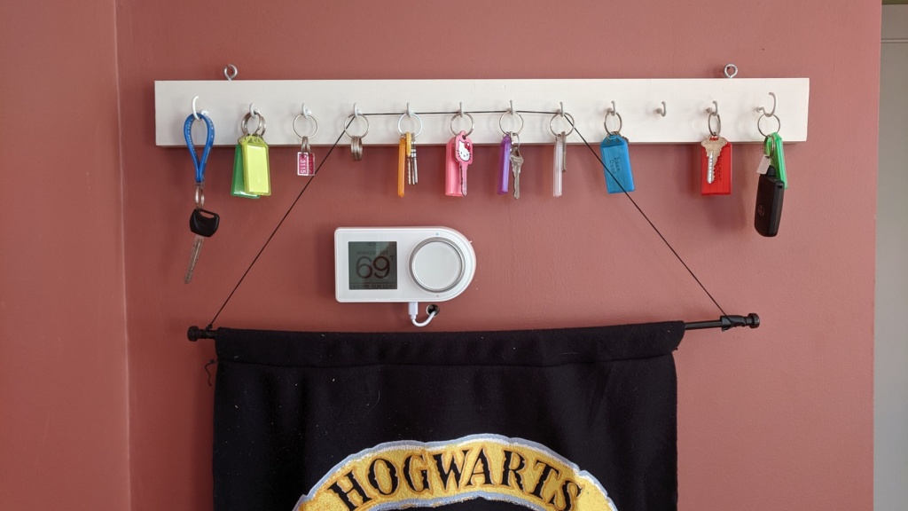 the smart thermostat is between the key organizer and hogwarts banner