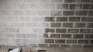 painting white drylok waterproofing sealant on the basement wall